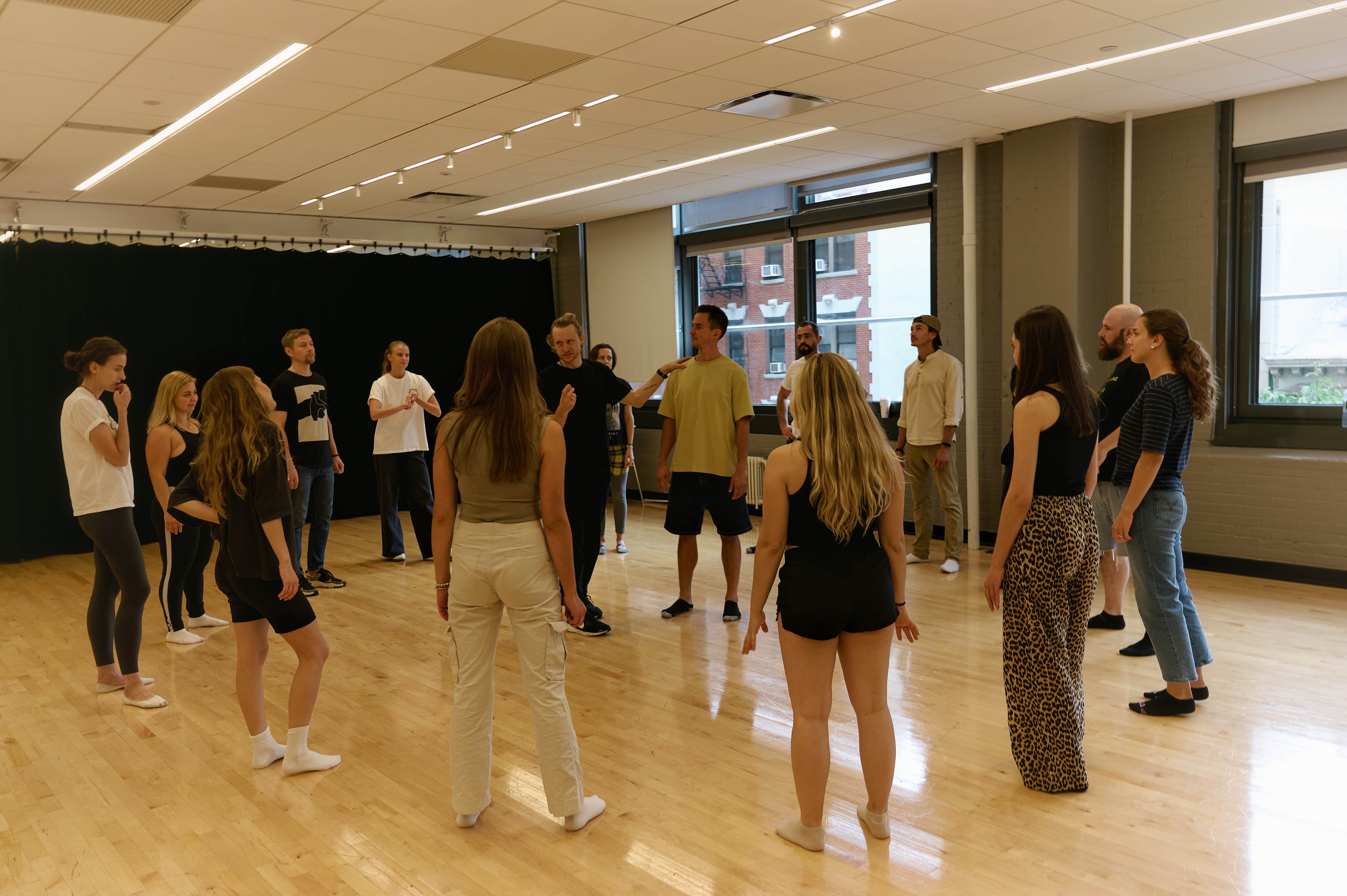 Large group of participants in circle formation during workshop exercise
