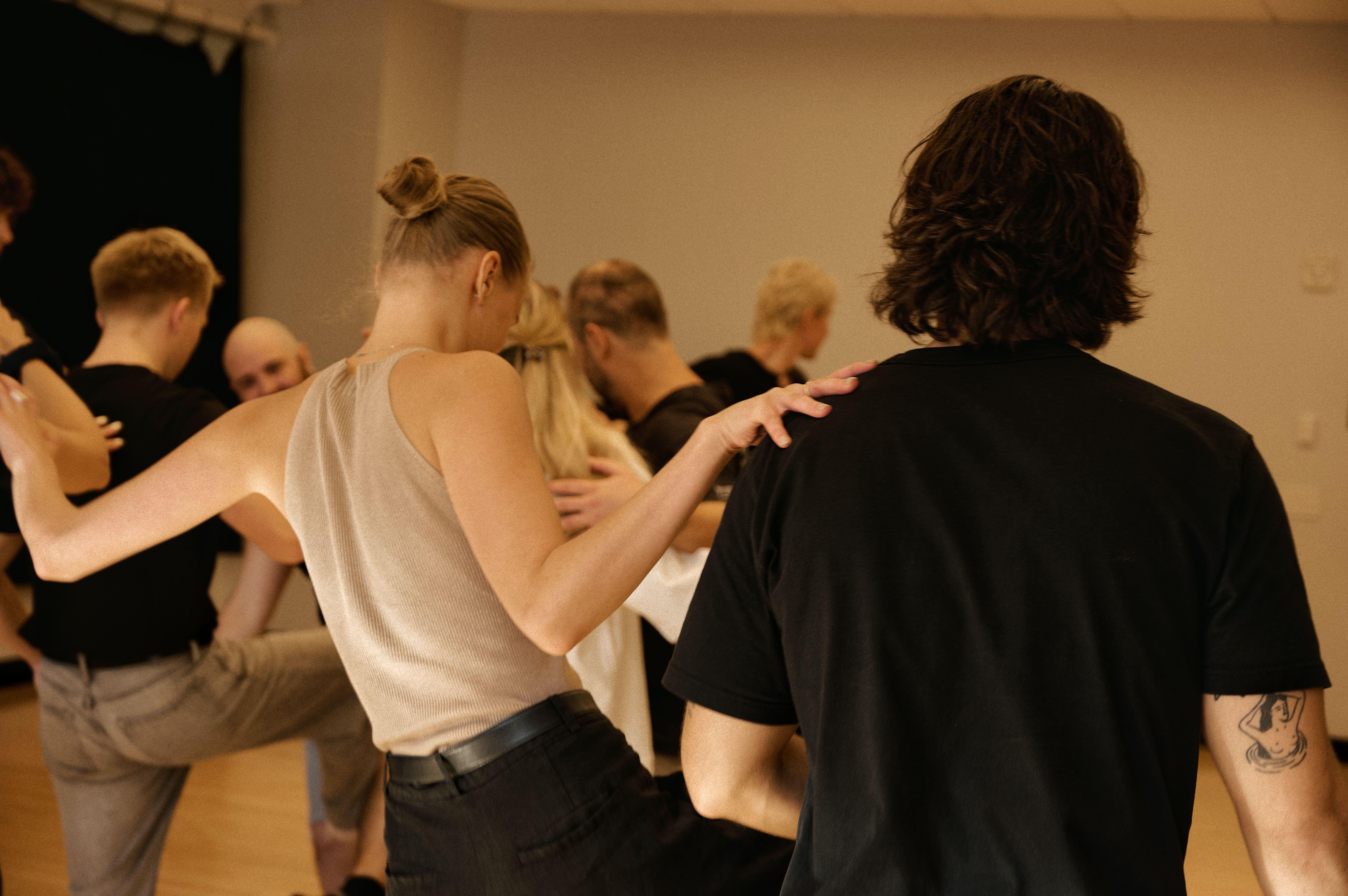 Participants in supportive group exercise with hands on shoulders